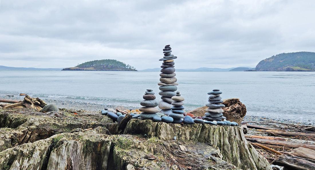 Seaside photo featuring rock cairns.
