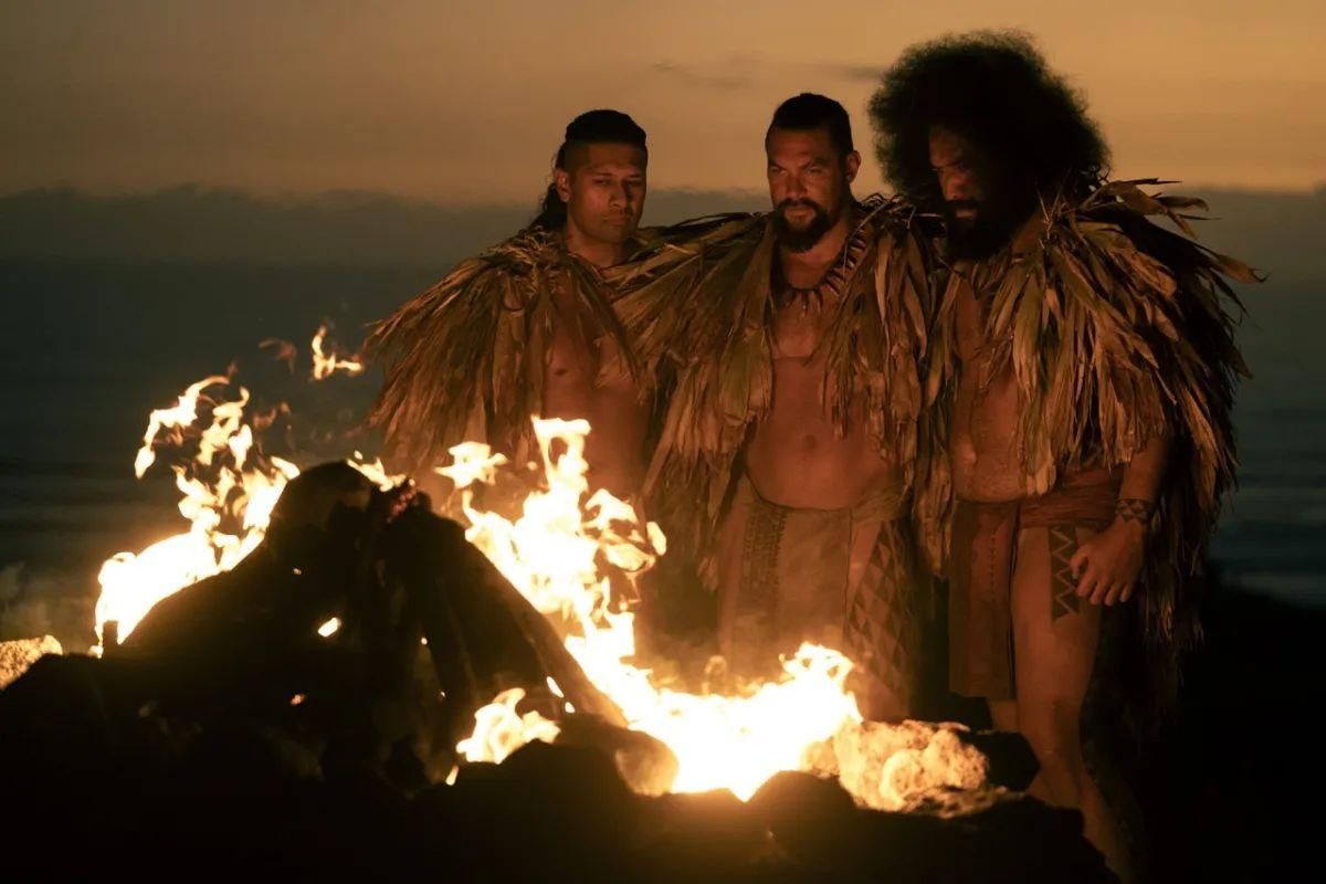 Jason Momoa, center, stars as warrior Ka’iana in the new film, "Chief of War," as he battles to unify the Pacific islands before Western colonization. In this scene from the film, he is joined by Te Kohe Tuhaka, left, and and Siua Ikale’o. The film debuted Aug. 1, 2025, on Apple TV+. Credit: Courtesy of Apple TV Jason Momoa Back in Action in ‘Chief of War’